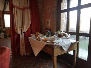 un tavolo con cibo sopra in una stanza con finestre di Agriturismo I Marzemini a Legnaro