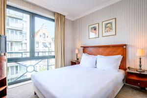 a bedroom with a bed and a large window at B-aparthotel Ambiorix in Brussels