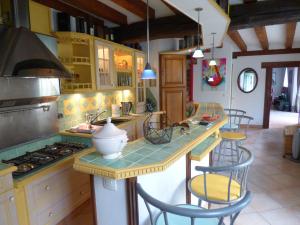 a kitchen with a counter with chairs and a stove at Au 13 in Vinneuf