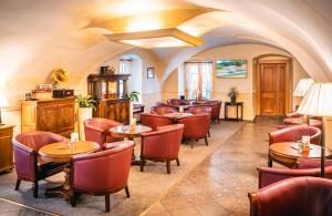 um restaurante com mesas e cadeiras num quarto em Hotel Elite Prague em Praga