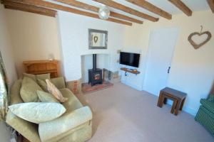a living room with a couch and a fireplace at Wish Cottage in Ratton Village
