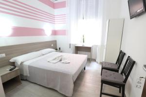 ミラノにあるアルベルゴ レオナルド ダ ヴィンチのベッドと椅子付きのホテルルーム
