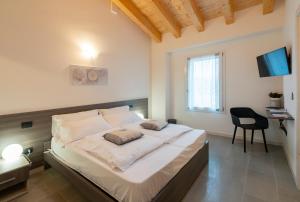 a bedroom with a large bed with a chair and a desk at B&B Terrebianche in Lavagno