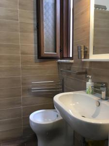 a bathroom with a white sink and a toilet at Sea House Kamaraton in Marina di Camerota