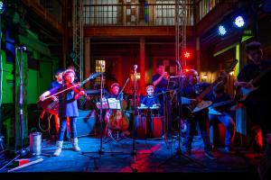 a group of people playing instruments on a stage at Socialtel Candelaria Bogotá in Bogotá