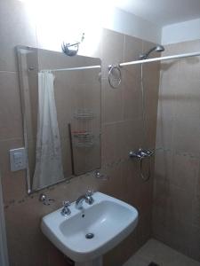 a bathroom with a sink and a shower with a mirror at Villasol Temporario in Córdoba +6 photos