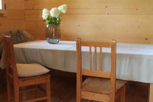 een tafel met een vaas met bloemen en twee stoelen bij Holzchalet in Kirchanschöring