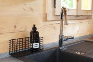 a bottle of wine is sitting on a kitchen sink at Holzchalet in Kirchanschöring
