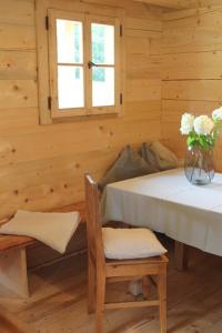 ein Holzzimmer mit einem Tisch und einer Vase aus Blumen in der Unterkunft Holzchalet in Kirchanschöring
