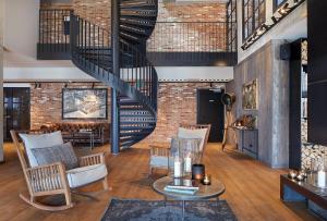 a living room with a staircase and a brick wall at Lighthouse Hotel & Spa in Büsum