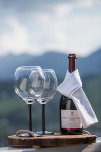 eine Flasche Wein und zwei Weingläser auf dem Tisch in der Unterkunft Winzig Apartment in Schladming