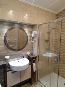 a bathroom with a sink and a shower with a mirror at La Cristina in Slatina +45 photos