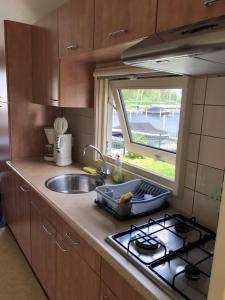 eine Küche mit einer Spüle, einem Herd und einem Fenster in der Unterkunft Vinkestek Verhuur in Vinkeveen