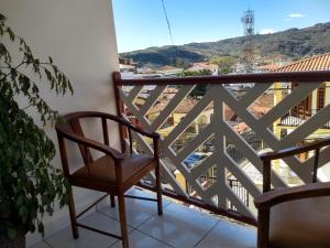 a chair on a balcony with a view at Pousada Vale do Garimpeiro in Diamantina