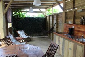 a patio with a table and chairs and a kitchen at Résidence Bois Flotté in Sainte-Anne
