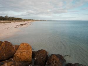 a beach with some rocks in the water at FortyOne - Oceanside Retreat Busselton in Busselton