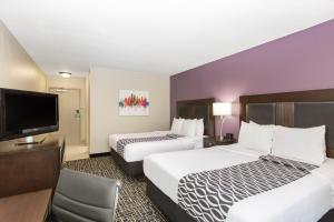 een hotelkamer met twee bedden en een flatscreen-tv bij La Quinta by Wyndham Blue Springs in Blue Springs