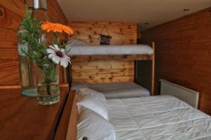 a bedroom with a vase of flowers on a table at Ruka Antu Ecolodge in Cobquecura