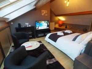 a bedroom with a bed and two chairs and a tv at Ô Spa Champenois in Écueil