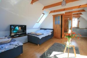 a living room with two beds and a tv at Uroczysko Teremiski in Białowieża