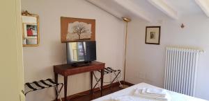 a room with a tv on a table with a bed at B&B Griffoni 7 in Bologna