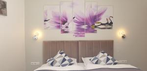 1 dormitorio con 1 cama con pinturas florales moradas en la pared en Villa Toni Design Apartments, en Split