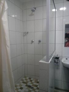y baño con ducha y lavamanos. en Otentik guesthouse, en Mbabane