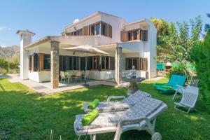 a backyard with a house with a table and chairs at S'Olivaret -Alcudia- in Port d'Alcudia