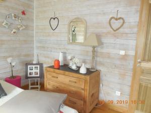ein Schlafzimmer mit einer Holzwand mit einem Bett und einer Kommode in der Unterkunft La maison bleue in LʼIsle-sur-la-Sorgue