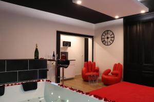 ein Wohnzimmer mit roten Stühlen und einer Badewanne in der Unterkunft Bulle de Spa in Lyon