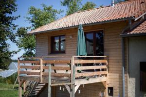 a house with a deck with an umbrella at Gîte la ferme de Baffour in La Chaise-Dieu