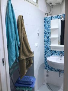 łazienka z niebieskimi ręcznikami i umywalką w obiekcie TAVERNETTA SUL PORTO w mieście Ischia