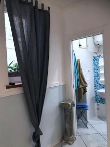 czarna zasłona w łazience obok okna w obiekcie TAVERNETTA SUL PORTO w mieście Ischia