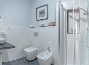 a white bathroom with a toilet and a shower at Affitacamere JIL in Sìnnai +46 photos