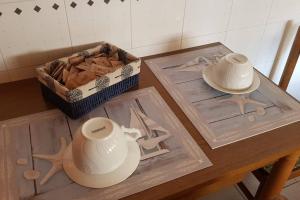 a wooden table with a box of cookies and two vases at La casa di Ulisse 008055- LT0806 in Sanremo