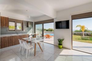 a kitchen and dining room with a table and chairs at Villa Sea La Vie in Kiotari