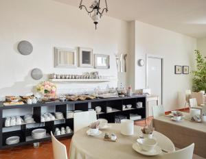 a dining room with two tables and a shelf with dishes at Albergo Garnì Villa Moretti in Riva del Garda