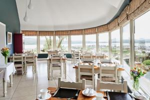 a restaurant with tables and chairs and large windows at Greenmount House in Dingle