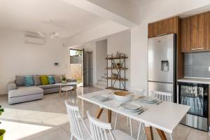a kitchen and living room with a white table and chairs at Villa Sea La Vie in Kiotari