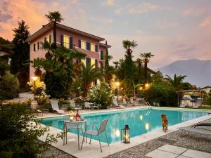 una casa con una piscina con un cane di fronte di Albergo Garnì Villa Moretti a Riva del Garda