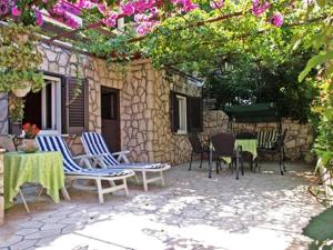 an outdoor patio with chairs and a table and flowers at Guest House Foretić in Dubrovnik