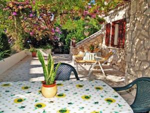 a table and chairs with a potted plant on a patio at Guest House Foretić in Dubrovnik