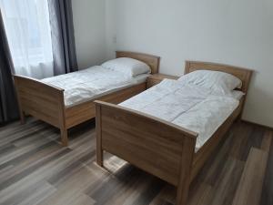 two twin beds in a room with wooden floors at Davidoff Hotel in Hannover