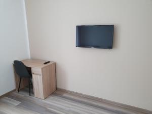 a room with a desk and a television on a wall at Davidoff Hotel in Hannover