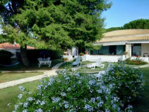 uma casa com um quintal com um banco e flores em Villa Mazzei em Siracusa