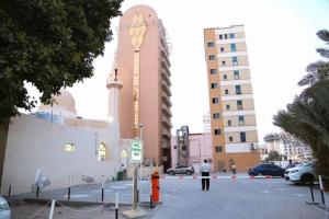 Al Sharq Hotel - BAITHANS في الشارقة: رجل واقف في موقف امام مبنى