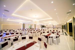 Holiday Resort في Velika Slatina: قاعة احتفالات بطاولات بيضاء وكراسي وثريات
