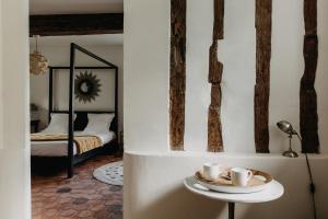 Una habitación con una mesa con tazas y una cama en La Dime de Giverny - Chambres d'hôtes en Giverny