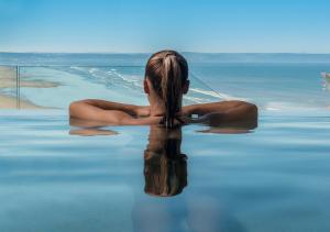 
a woman in a bikini sitting in a pool of water at Saunton Sands Hotel Source Spa and Wellness in Braunton
