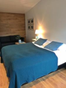 una camera da letto con un grande letto con una coperta blu di Thoristun Apartments a Selfoss